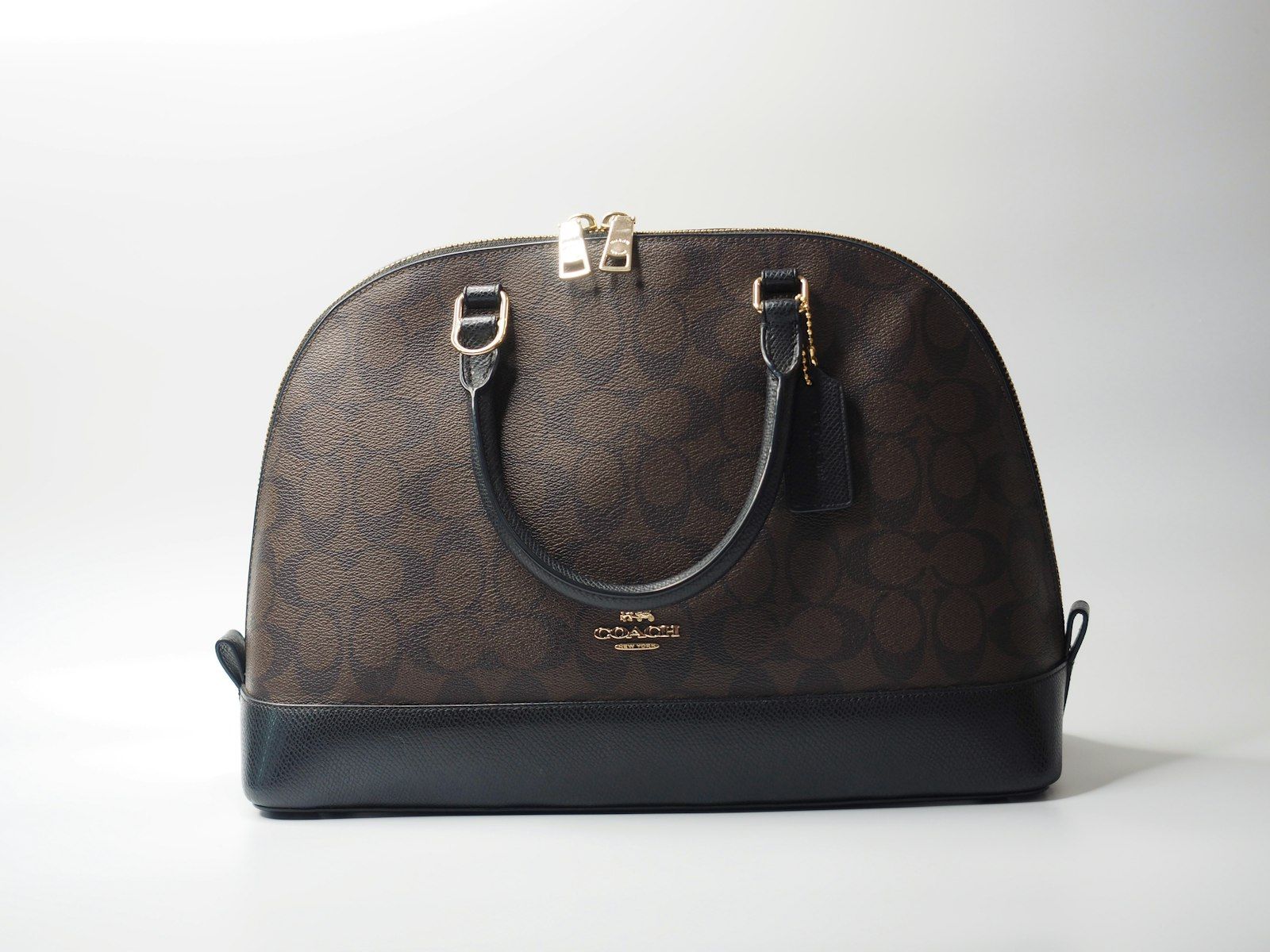 Tas kulit cognac buatan tangan di atas meja kerja atelier